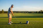 Golfer using Swing Caddie Launch Monitor on driving range